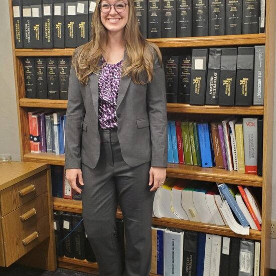 Paige Ricks in front of bookshelf full of books